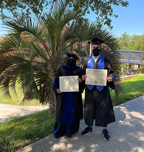 International graduates Reema Alhowaish and Abdul Almaghlooth pose on campus with their degrees.