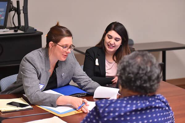 Two law students help a client.