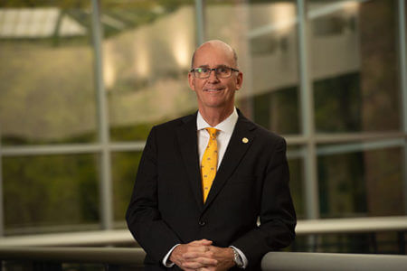 Thomas M. Mengler leans on a bannister in the University Center.