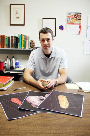 Ted Macini in his office with pictures of animal brains.