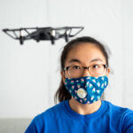 A student flies a drone in the lab.