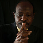 Paul Rusesabagina folds his hands in thought.