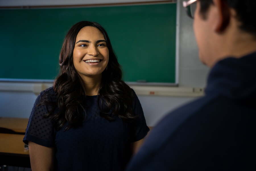 Student smiling at professor in classroom