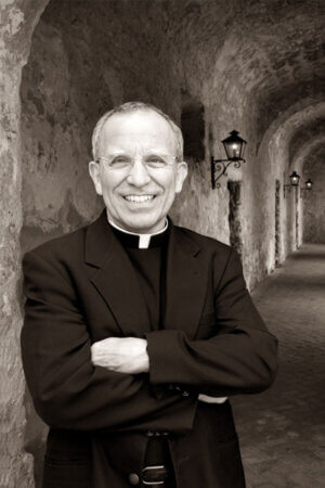 Father David Garcia stands along the wall of one of the Missions. 