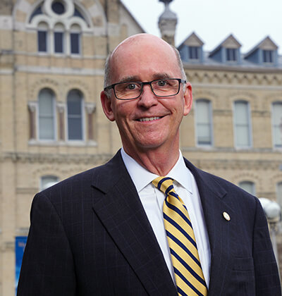 President Tom Mengler stands in front of St. Louis Hall.