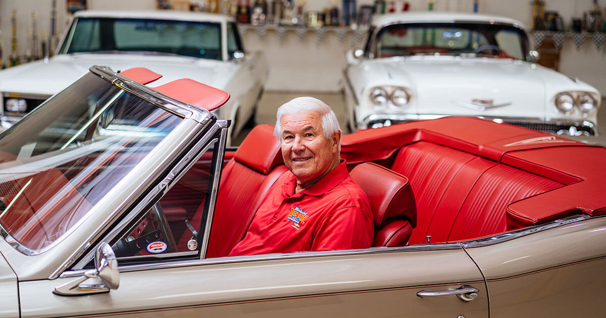 John Sieffert poses in one of his classic cars.