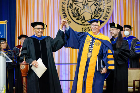 Charles Anderson, left, and President Thomas Mengler, J.D., stand on stage during the Spring 2022 commencement. 