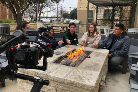 Students roast s'mores outside a residence hall.