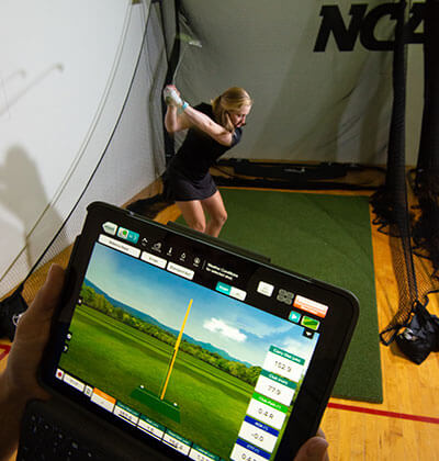 A Golf player takes a swing and analyzes it with technology