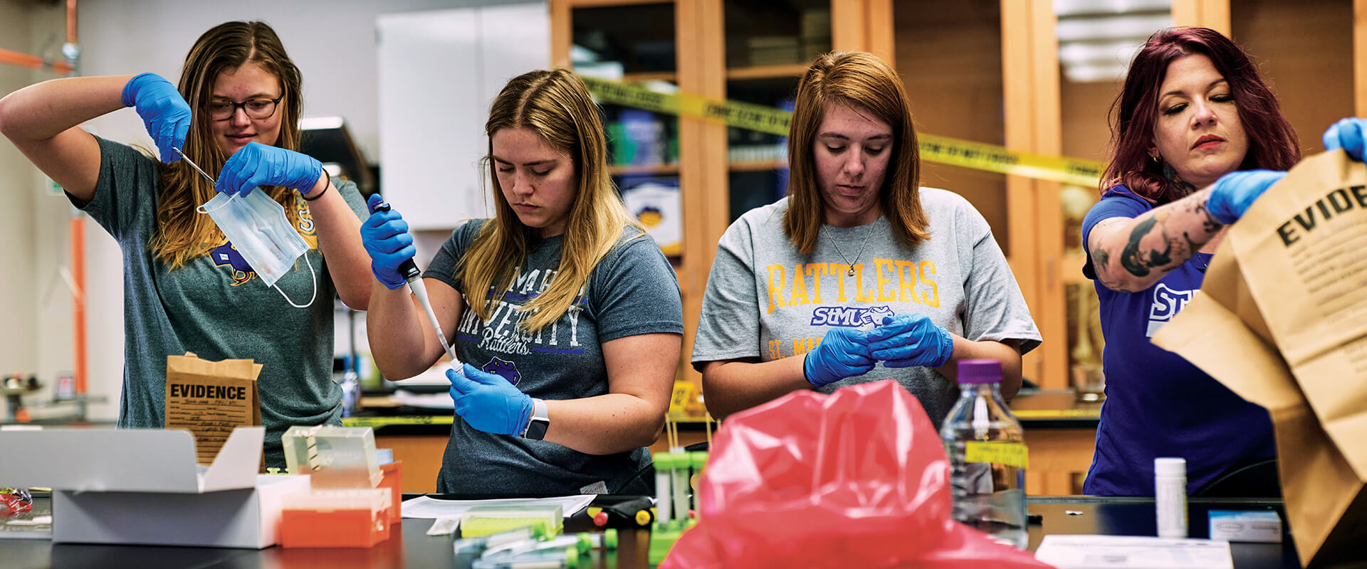 Four forensic science students analyze DNA and crime scene evidence