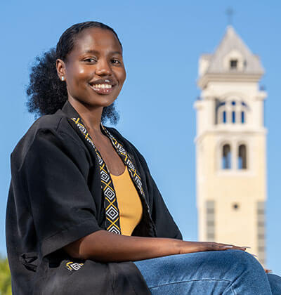 Christine Nduhura sits in front of the Bell Tower