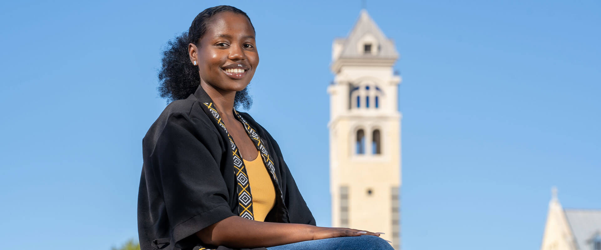 Christine Nduhura sits in front of the Bell Tower