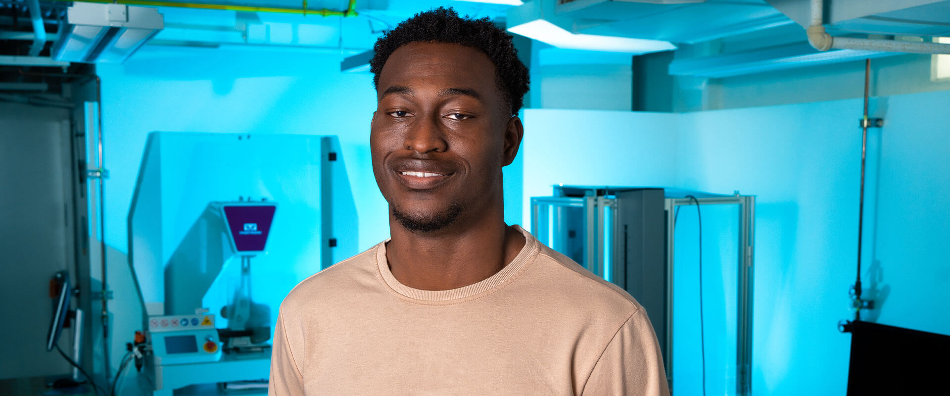 Emmanuel Ewuzie stands in a Mechanical Engineering lab.