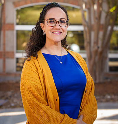 Vanessa Ortega stands in front of the Sarita Kenedy East Law Library.