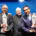 Father Jim Tobin, center, celebrates Prasad Padmanabhan, left, and Ajaya Swain for receiving Marianist Heritage Awards
