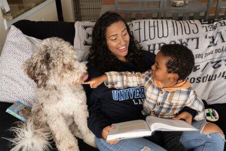 Rebeca Thompson, her Jayden-Levi, and their dog, Ash, review a law school textbook in their home in Lake Worth, Florida.