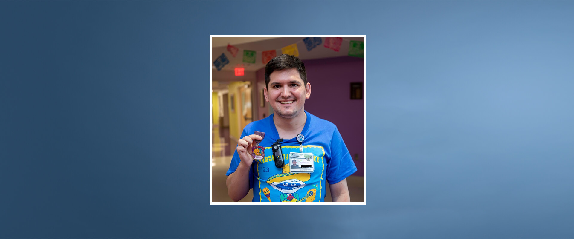Enrique Salinas became a nurse at CHRISTUS Children's. Here he holds up a Fiesta medal while wearing a Fiesta Oyster Bake T-shirt at the hospital.
