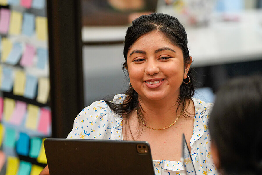 A student smiles while working with a tutor in the Rattler Student Success Center