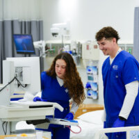 Two nursing students work together using innovative technology.