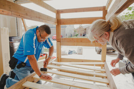 Winston Erevelles, left, and his wife, Chritine Erevelles, take turns constructing bunk beds for a family in need in March through the nonprofit Sleep in Heavenly Peace.