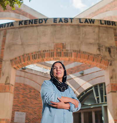 Woman standing with arms crossed outside of Law school Library