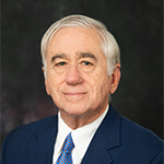 Portrait of Mark Stevens in a dark suit with white shirt.