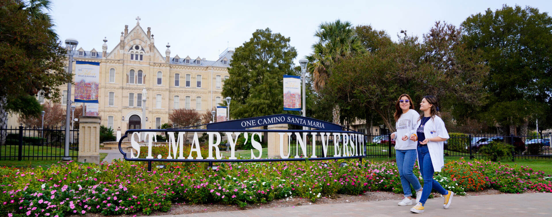 two students walk in front of the St. Mary's University sign