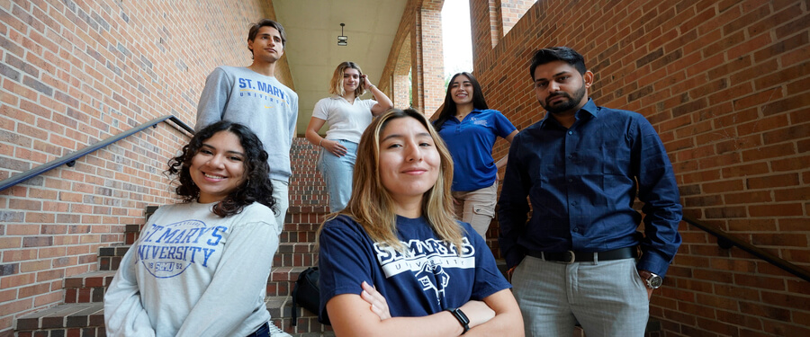 a group of international students gather on the library stairs