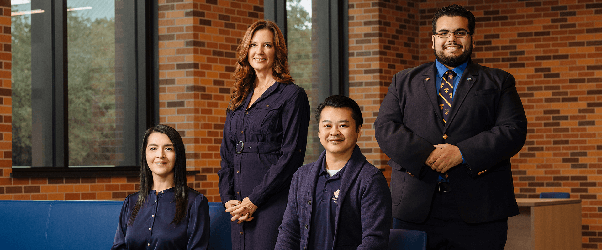 Four individuals wearing blue and gold standing at St. Mary's University