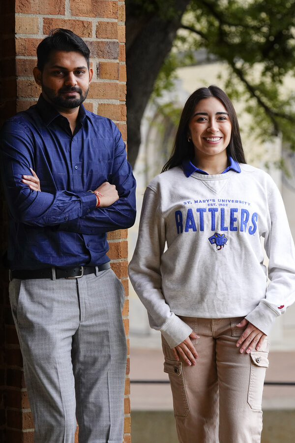 two students standing and smiling