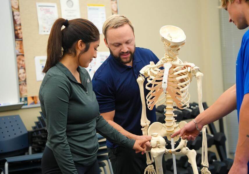 Two students and a professor use a model skeleton in the new Human Performance Lab at St. Mary's.
