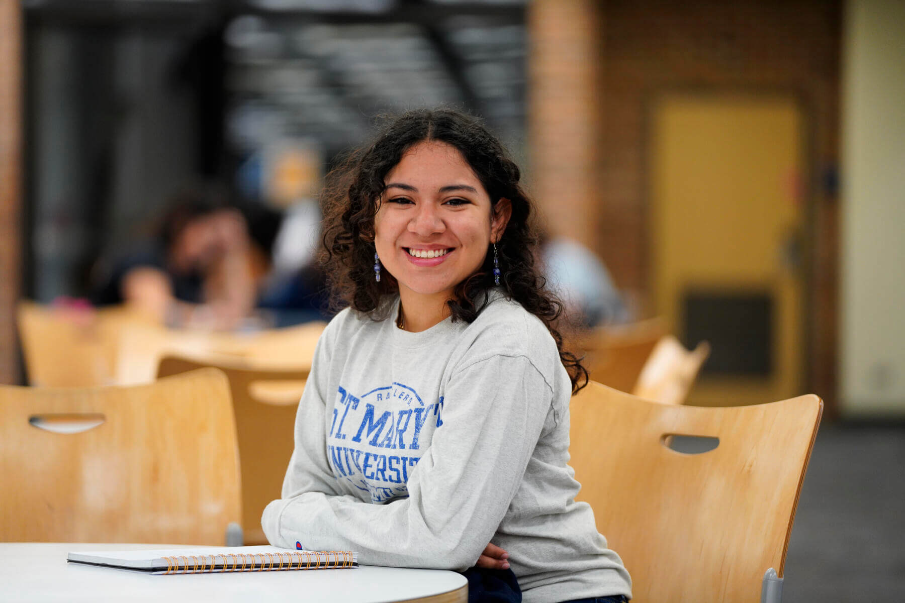 St. Mary's University student with a bright smile studies in the Blume Library