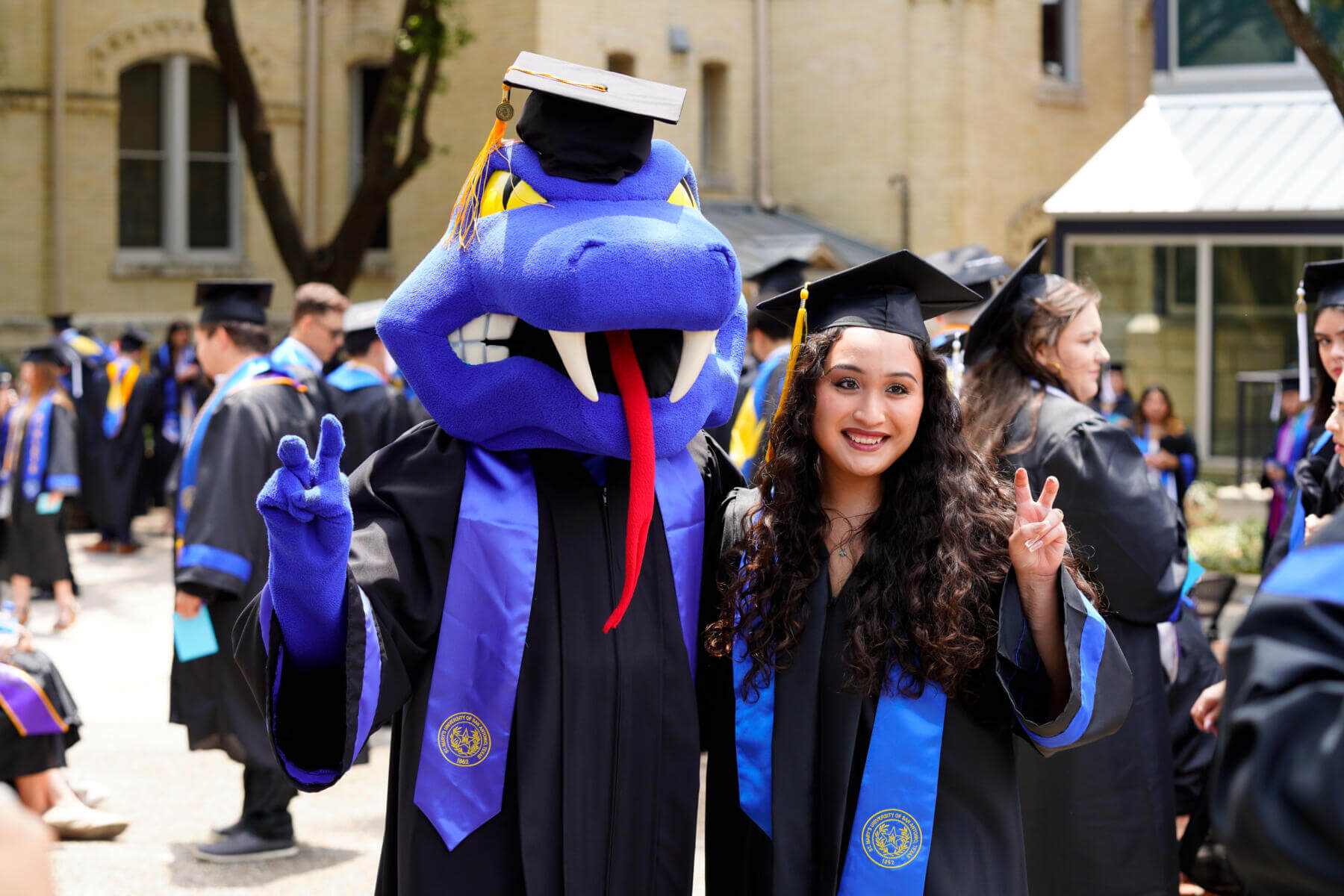 St. Mary's Graduation with Rattlerman and female graduate outside on a beautiful sunny day