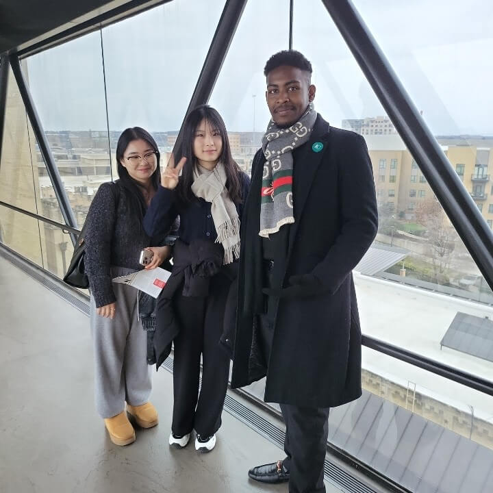 Intensive English Program students walk across the museum skywalk and take a fun photo together