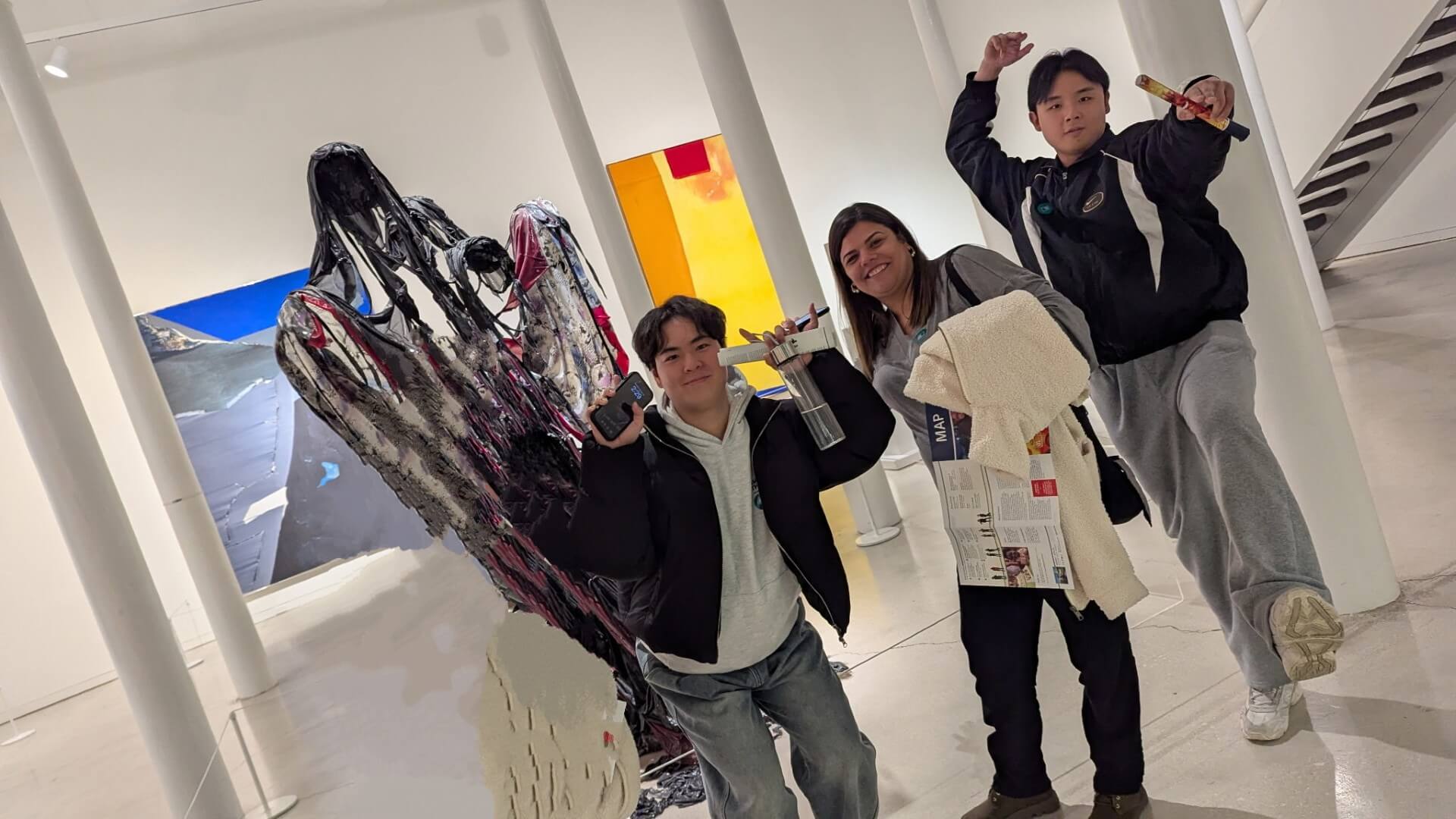 Intensive English Program students visit the museum posing in front of a modern art piece in creative ways.