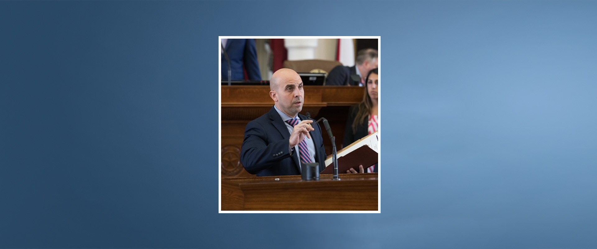 Blue banner with photo of State Rep. Armando Martinez on Legislative floor in Austin.