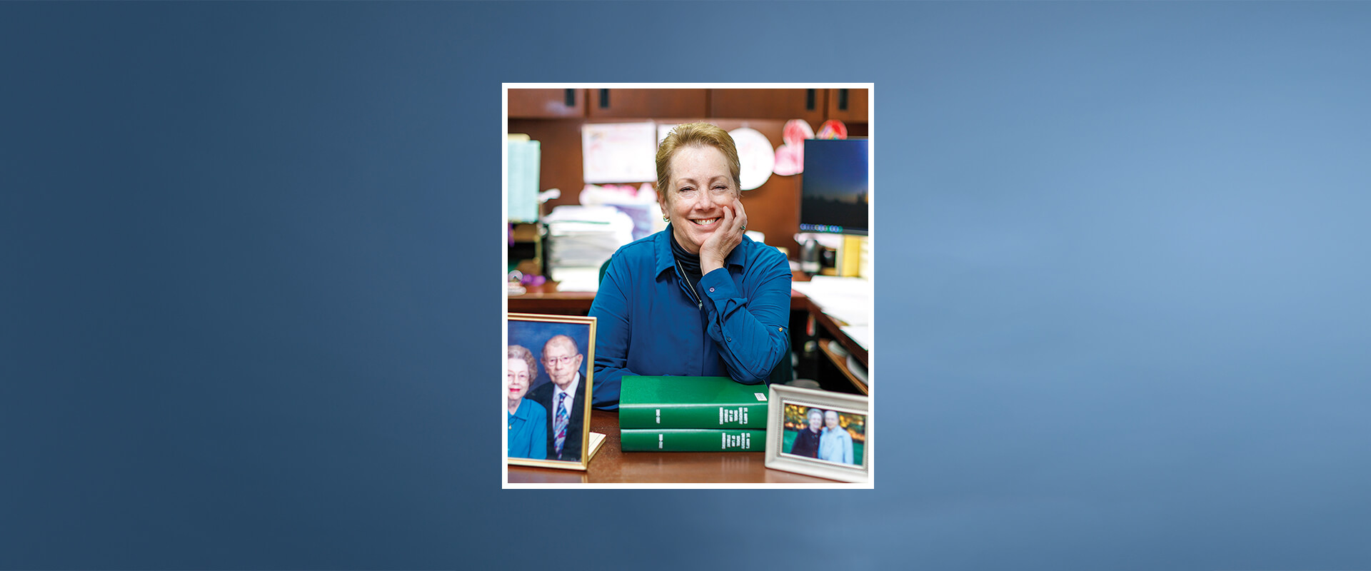 Yvonne Olfers is sitting at her desk with photos of her parents in front of her.