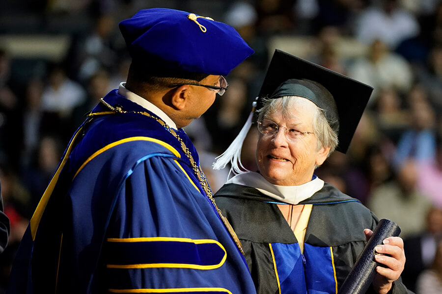 Patricia Howey, who is the first graduate to earn a Master of Jurisprudence with a concentration in Special Education Advocacy, accepts her degree on stage during Fall 2024 Law Commencement.