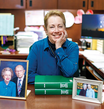 Yvonne Olfers is sitting at her desk with photos of her parents in front of her.
