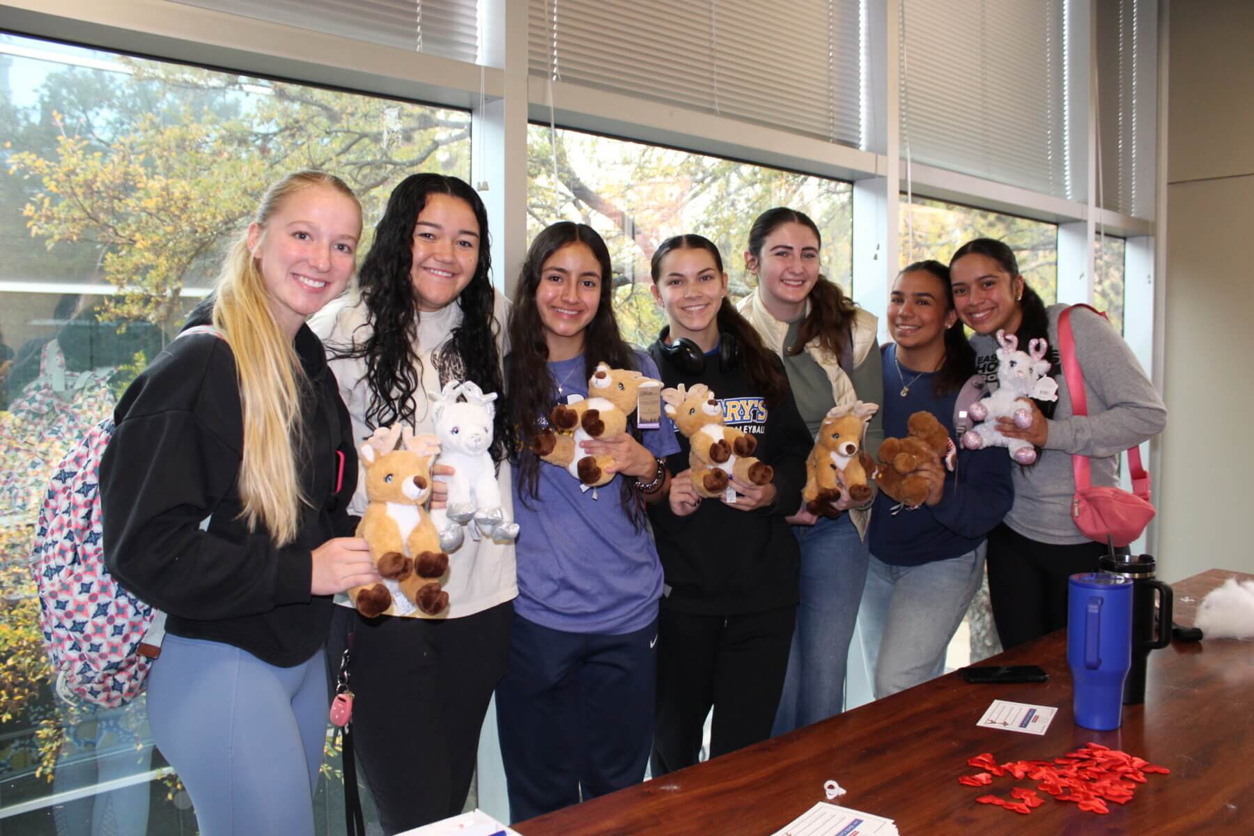 Female students hold stuffed animals they made during Study Days.