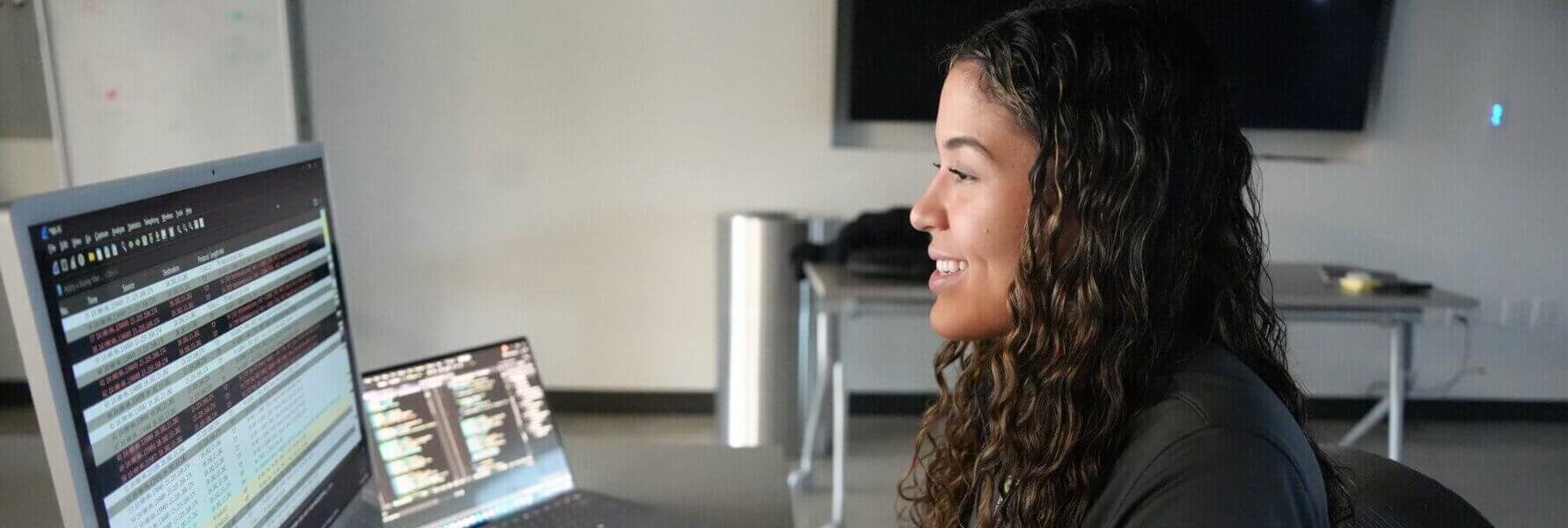 Smiling student using computer.