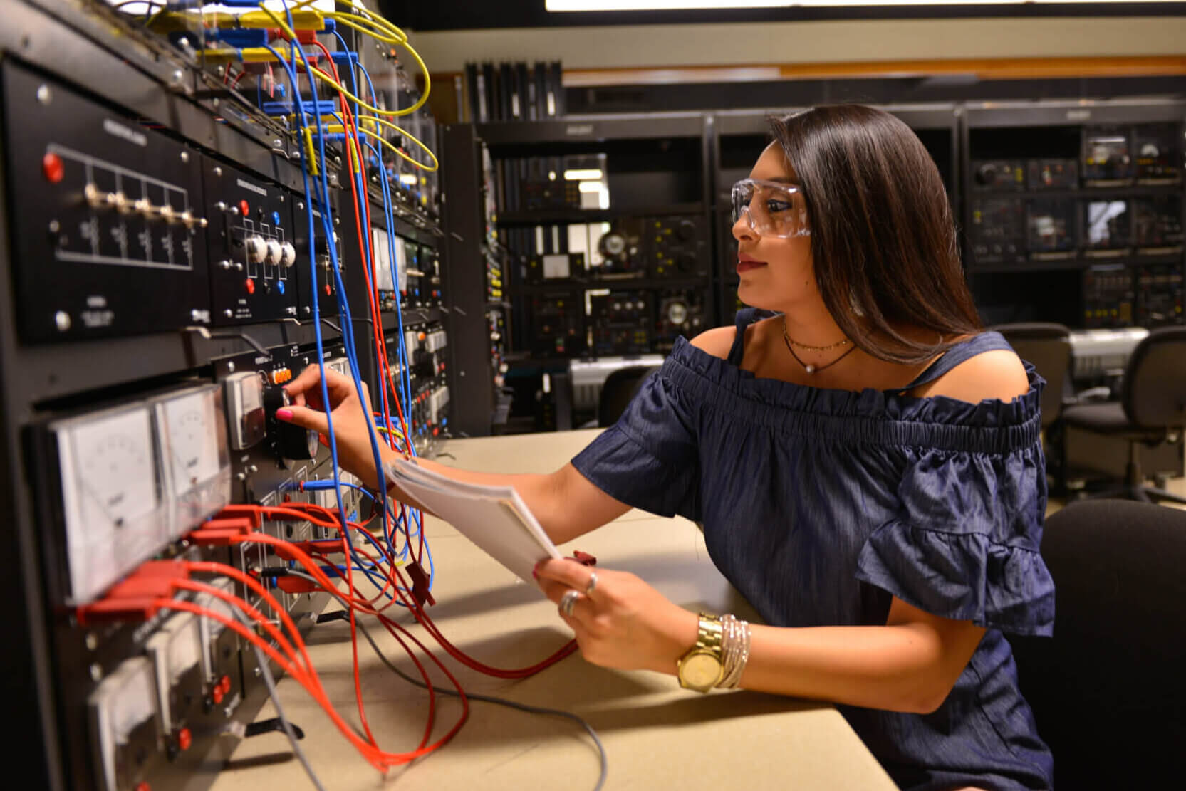 Engineering student connects wires during lab.