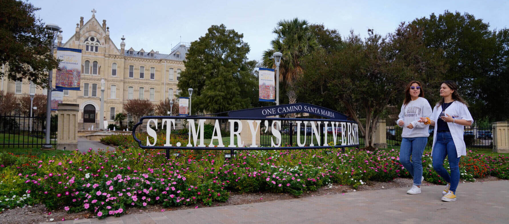 Students walking in front the St. Mary's University sign by St. Louis Hall
