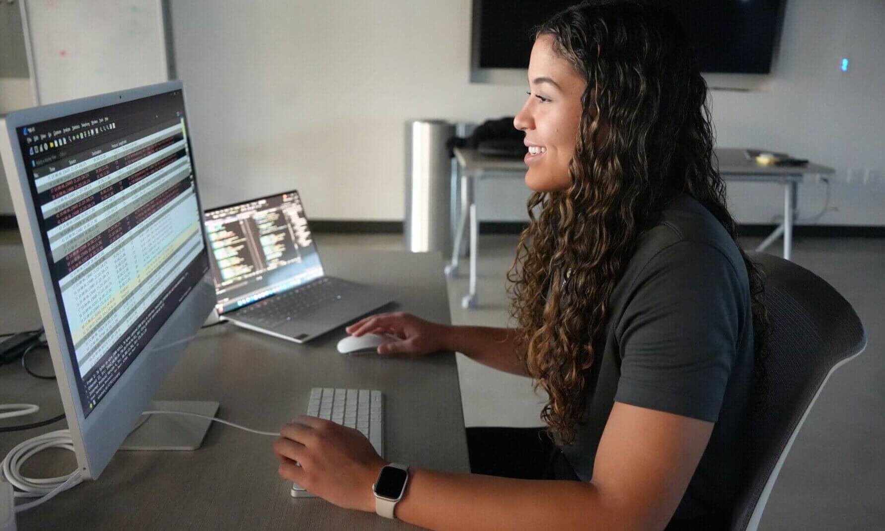 Smiling student using computer in the Machine Learning Lab.