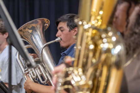 Male students in the band play their instruments.
