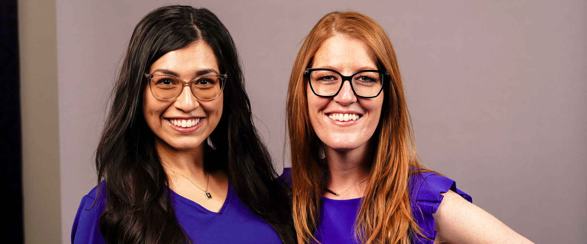 Gaby Aquino, Ph.D. (B.A. ’19), left, wears blue for a photoshoot with Professor of Psychology Jillian Pierucci, Ph.D.