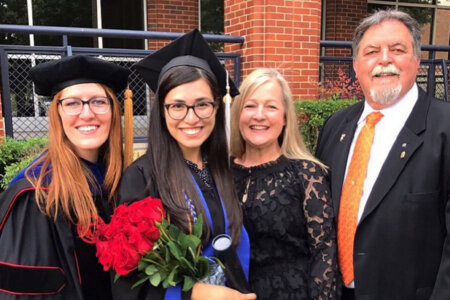 Professor of Psychology Jillian Pierucci, left, celebrates the graduation of Gaby Aquino, Ph.D. (B.A. ’19), with loved ones outside Greehey Arena.
