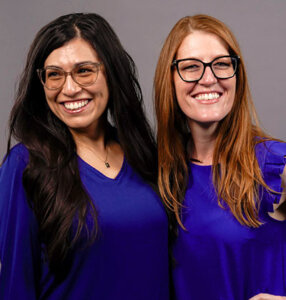 Gaby Aquino, Ph.D. (B.A. ’19), left, wears blue for a photoshoot with Professor of Psychology Jillian Pierucci, Ph.D.