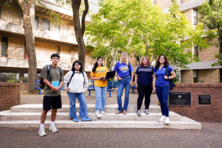 A group of students pose in the courtyard of Treadaway Hall, the home of the Music and Theatre Arts Department