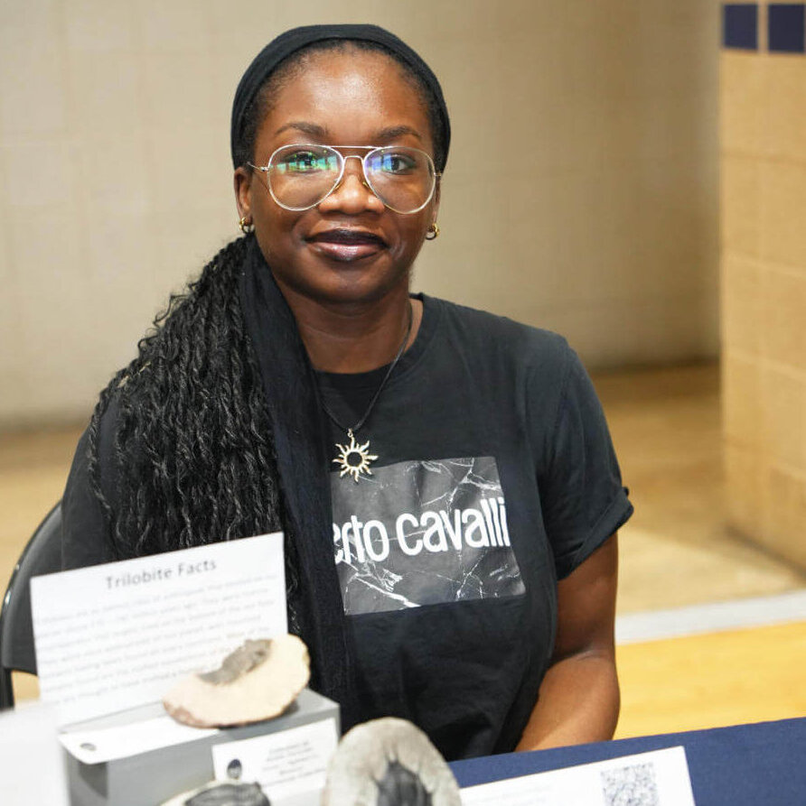 A faculty member stands by their research project.